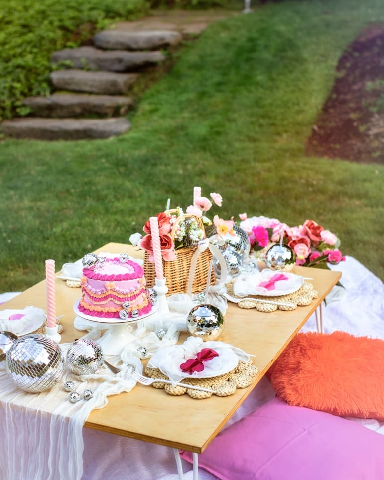 Beautifully styled outdoor table with a decorative cake and floral arrangements
